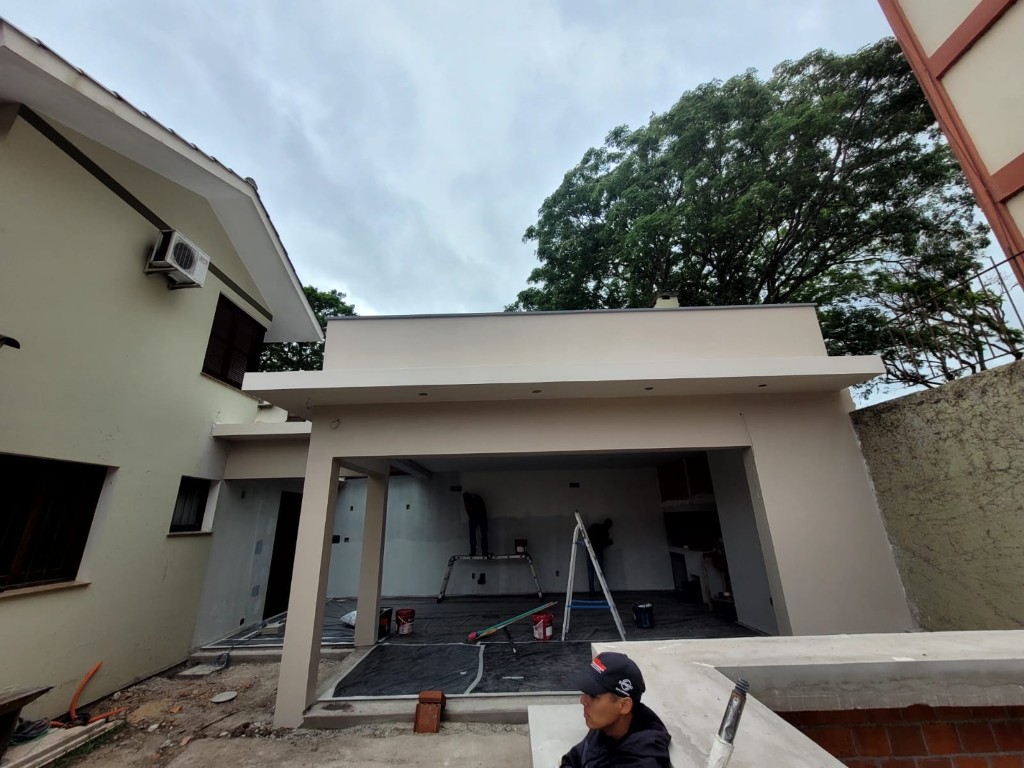 Pintura externa de área gourmet anexa à casa, com proteção de piso na obra